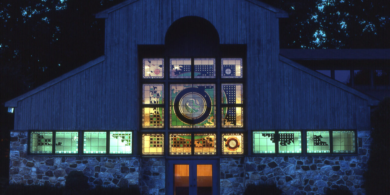Exterior of a church with a stained glass window.